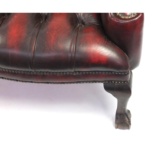 2003 - Chesterfield style burgundy leather three piece suite, comprising of a three seater wing back settee... 