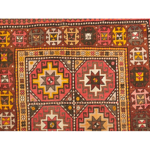 103 - Middle Eastern rug with geometric boarder onto a predominately brown ground, the central field decor... 