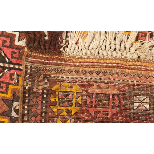 103 - Middle Eastern rug with geometric boarder onto a predominately brown ground, the central field decor... 