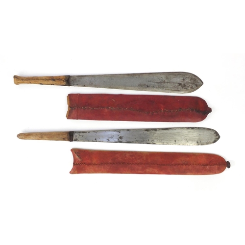 601 - Two Kenyan panga knifes with red sheaths, the longest 56cm long