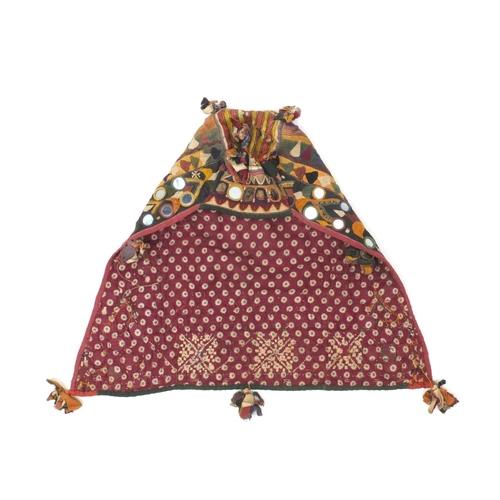 506 - Indian embroidery Ganesh Toran, together with a child's headdress, the headdress with geometric and ... 