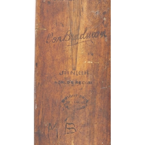 569 - Two cricket bats including a steel spring super short Harrods example and a Don Bradman Junior world... 