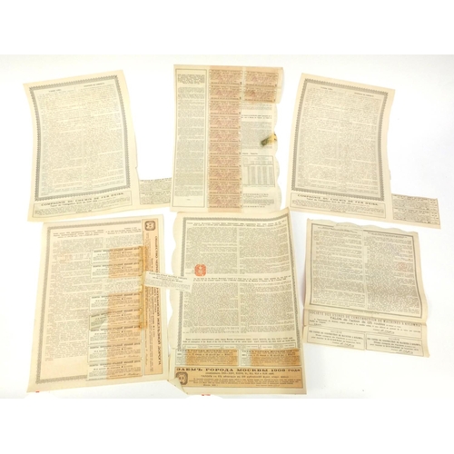 595 - Six Russian share certificates, some with attached bonds and stamps, the largest 41cm x 28cm