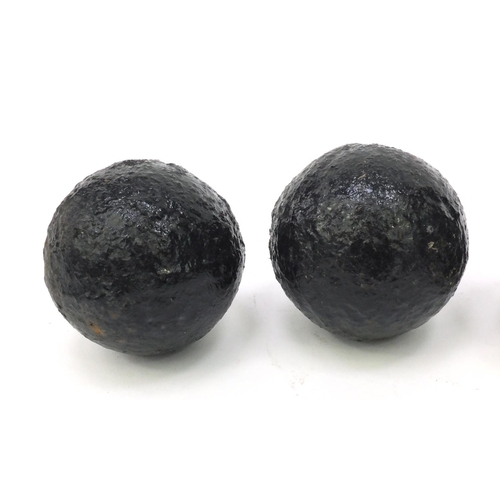 392 - Four antique cannon balls, each 7.5cm diameter