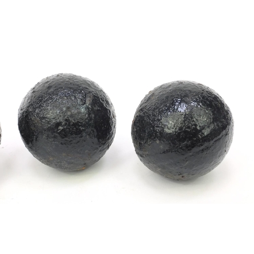 392 - Four antique cannon balls, each 7.5cm diameter