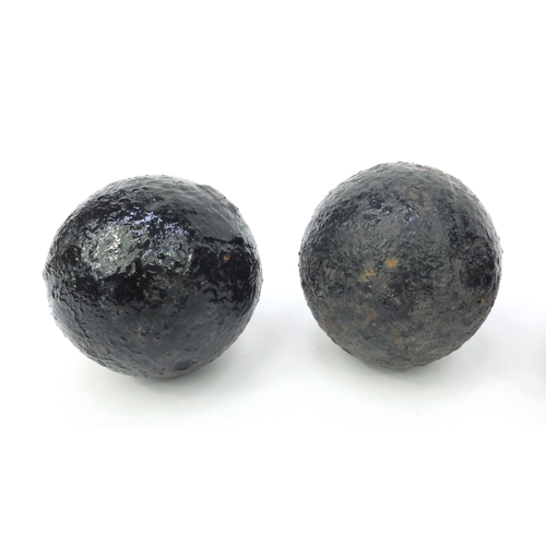 393 - Four antique cannon balls, each 7.5cm diameter