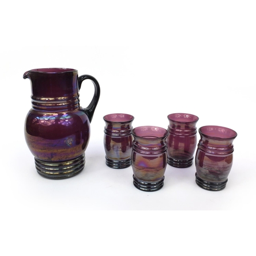 629 - Victorian purple iridescent glass jug together with four matching drinking glasses, the jug 23cm hig... 