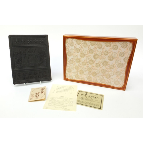 559 - Chinese compressed tea block decorated with script and three arches together with presentation box, ... 