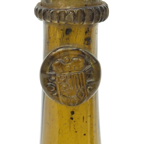 627 - Antique amber glass bottle with impressed crest to the neck, 22cm high