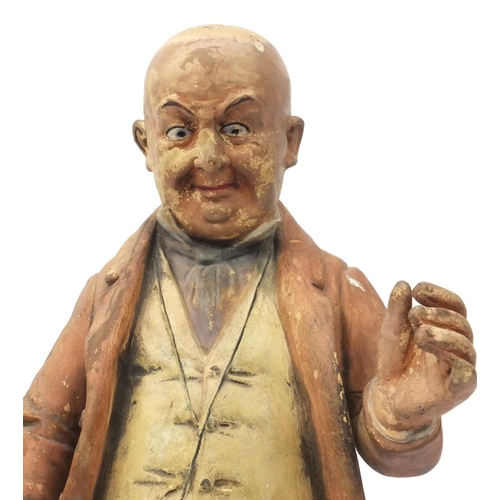 617 - Large terracotta figure of Mr Pickwick leaning against a font, 46cm high