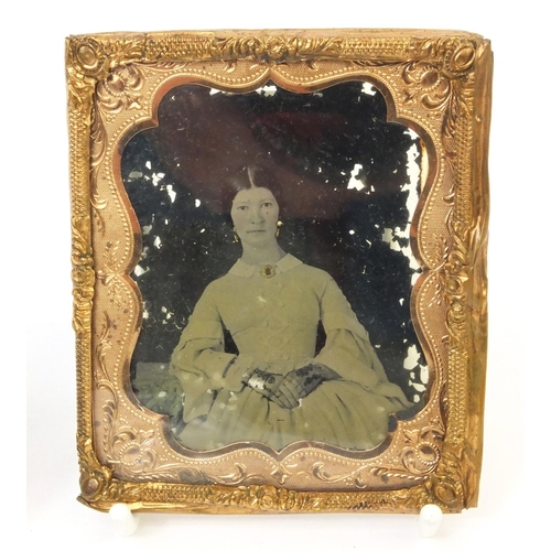 208 - Victorian daguerreotype of a seated female, housed in a pressed frame decorated with a figure before... 