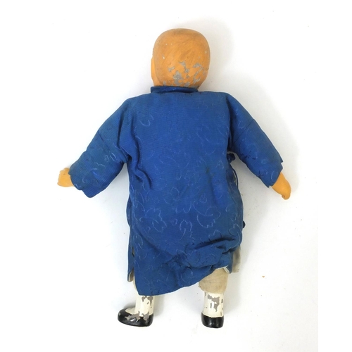 561 - Oriental doll of a man with composite head and limbs , with straw filled body, 28cm high