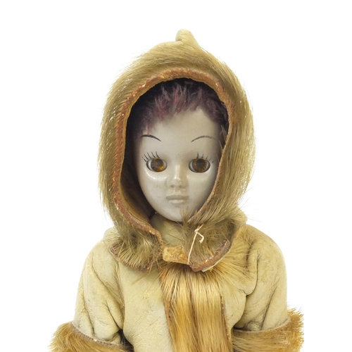 442 - Inuit doll wearing a leather and fur hooded jacket with open close eyes, 20cm high