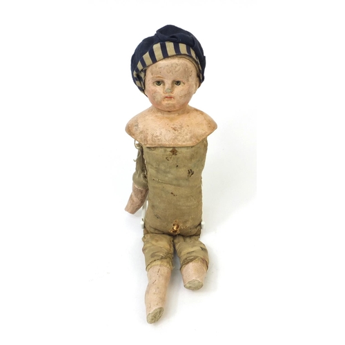 441 - Straw filled doll wearing a hat with composite head and limbs, 28cm high