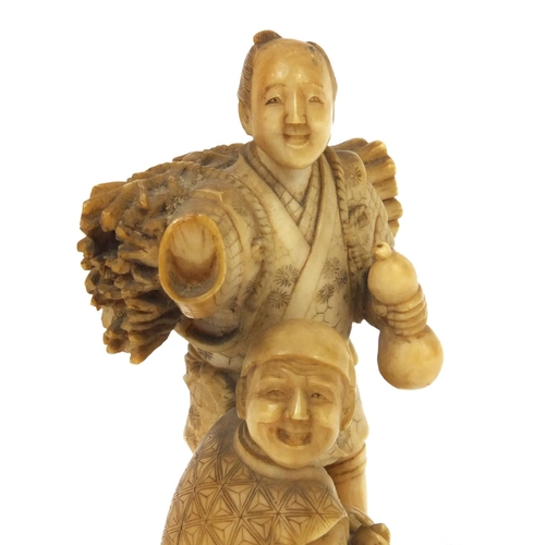 504 - Japanese carved ivory okimono of a wood carrier holding a double gourd sake bottle beside a seated e... 