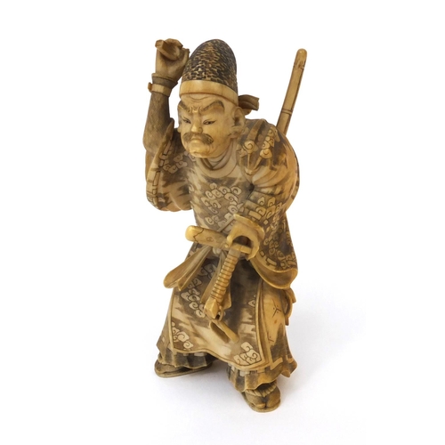 503 - Japanese finely carved ivory okimono of a samari warrior holding a katana and stick, signature to th... 