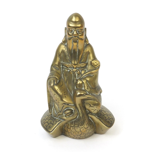 568 - Chinese brass Buddha riding a crane with incised decoration, 20cm high