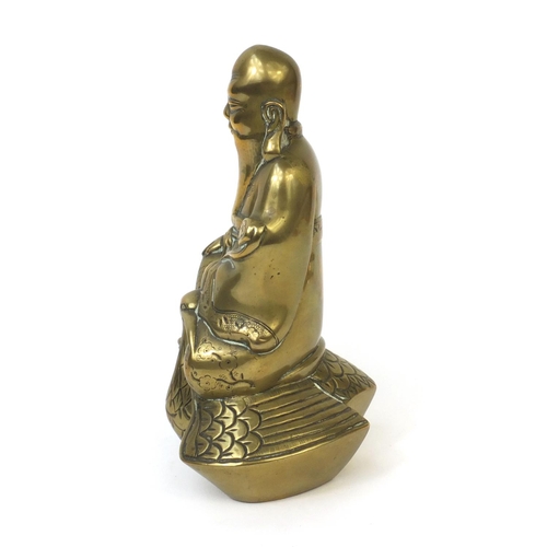 568 - Chinese brass Buddha riding a crane with incised decoration, 20cm high