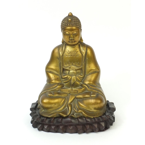 567 - Chinese brass Buddha raised on a hardwood stand, the Buddha with incised decoration and character ma... 