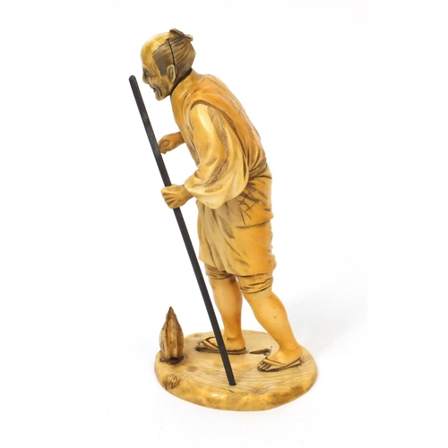 506 - Japanese carved ivory okimono of an elder holding a stick, character marks to the base, 20cm high