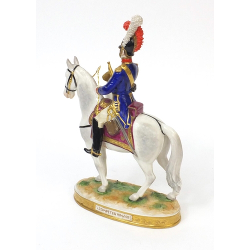 395 - Military interest hand painted porcelain figure of a trumpeter on horseback, factory marks to the ba... 