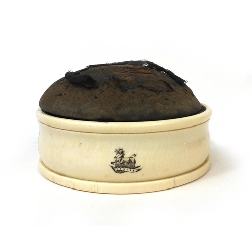 61 - Victorian ivory pin cushion with lift up lid, the base with engraved heraldic crest, 14cm wide