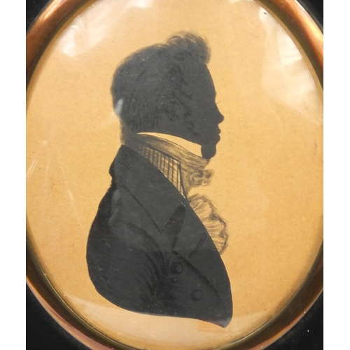 29 - Four 19th century oval silhouettes each of gentlemen wearing roughneck coats, all housed in ebonised... 