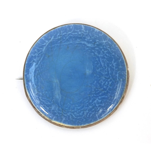 738 - Ruskin pottery randall mounted in a silver coloured metal brooch setting, factory marks to the rever... 