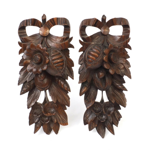 70 - Pair of black forest wall appliques carved with flowers and foliage, each 34cm