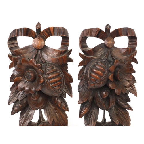 70 - Pair of black forest wall appliques carved with flowers and foliage, each 34cm