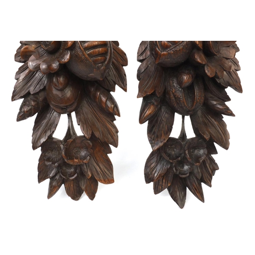 70 - Pair of black forest wall appliques carved with flowers and foliage, each 34cm