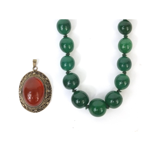 531 - Chinese silver gilt filigree locket pendant with together with a green jade beaded necklace, the nec... 