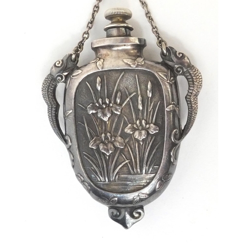 544 - Chinese silver scent bottle with dragon handles, the body embossed with flowers, impressed character... 