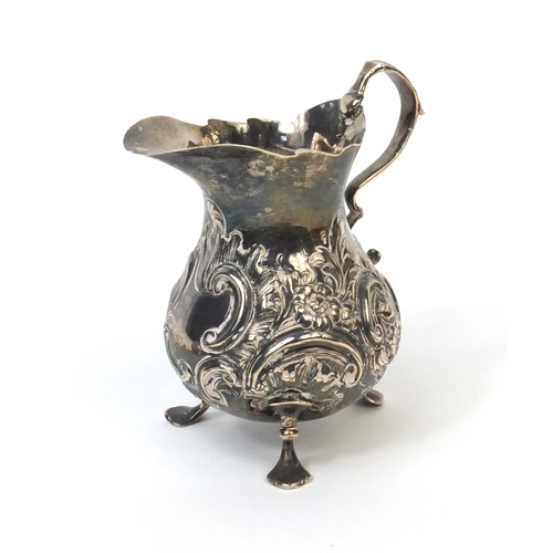 760 - Georgian silver three footed cream jug with embossed floral decoration, G.L London 1792, 12cm high, ... 