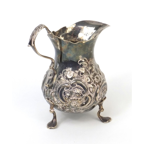 760 - Georgian silver three footed cream jug with embossed floral decoration, G.L London 1792, 12cm high, ... 