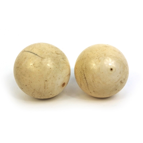 63 - Pair of Victorian ivory billiard balls, the larger 4.5cm in diameter