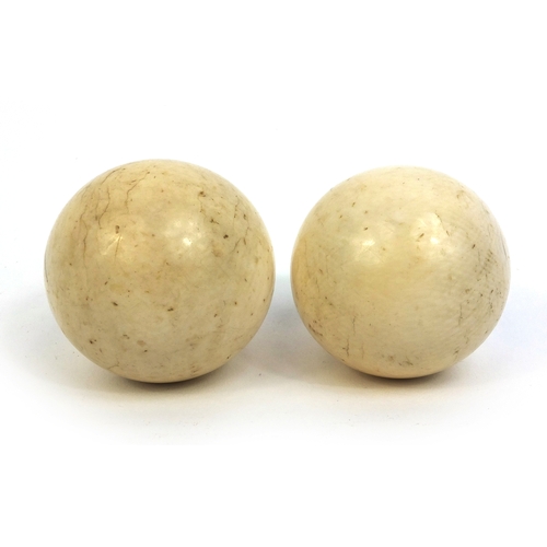 63 - Pair of Victorian ivory billiard balls, the larger 4.5cm in diameter