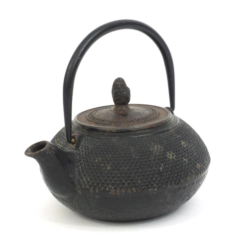 573 - Chinese cast iron tea pot with swing handle and acorn finial, character marks to the base, 10cm high... 