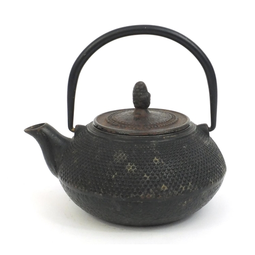 573 - Chinese cast iron tea pot with swing handle and acorn finial, character marks to the base, 10cm high... 