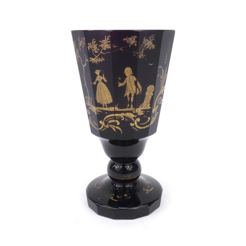 630 - Russian gilded amethyst glass goblet decorated with figures, 17cm high