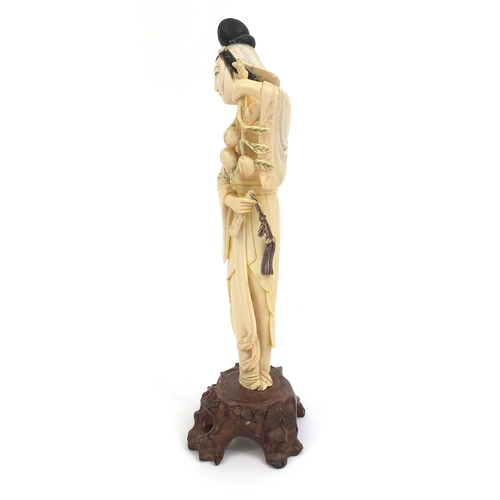 505 - Chinese carved ivory okimono of a girl holding flowers and wearing a robe, raised on a hardwood base... 