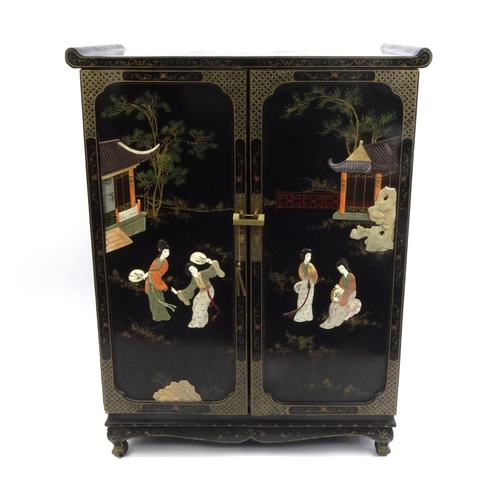 2026 - Oriental black lacquered two door side cabinet decorated in relief with soap stone, the top hand pai... 