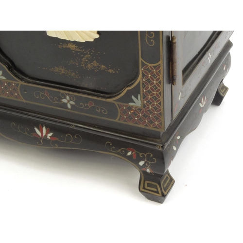 2027 - Oriental black lacquered two door side cabinet  decorated in relief with soap stone, hand painted wi... 