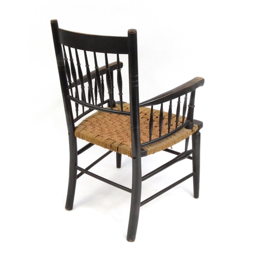 2047 - Morris style ebonised elbow chair with cane seat, 90cm high