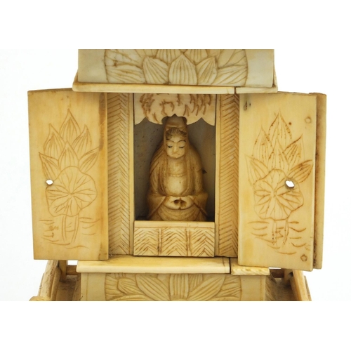 2357 - Oriental ivory pagoda opening to reveal a miniature Buddha, raised on a hardwood base, 26cm high