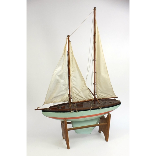 2288 - Vintage wooden pond yacht with canvas sails, raised on a stand, 98cm high