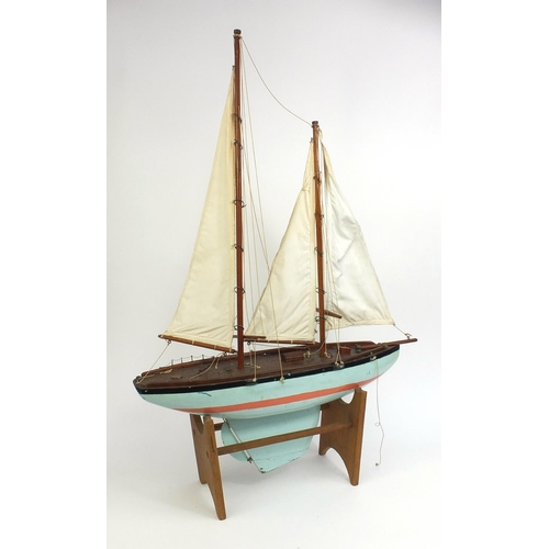 2288 - Vintage wooden pond yacht with canvas sails, raised on a stand, 98cm high