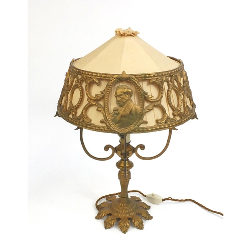 2163 - Gilt metal table lamp, the shade decorated with busts of gentlemen, 46cm high