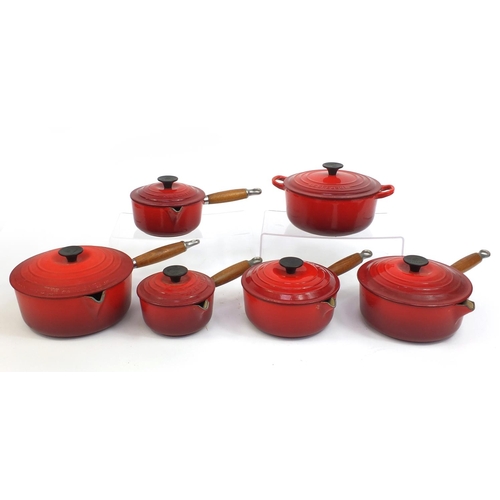 2315 - Group of Le Creuset red cast iron kitchenalia comprising graduated set of five lidded saucepans and ... 