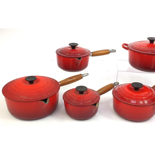 2315 - Group of Le Creuset red cast iron kitchenalia comprising graduated set of five lidded saucepans and ... 